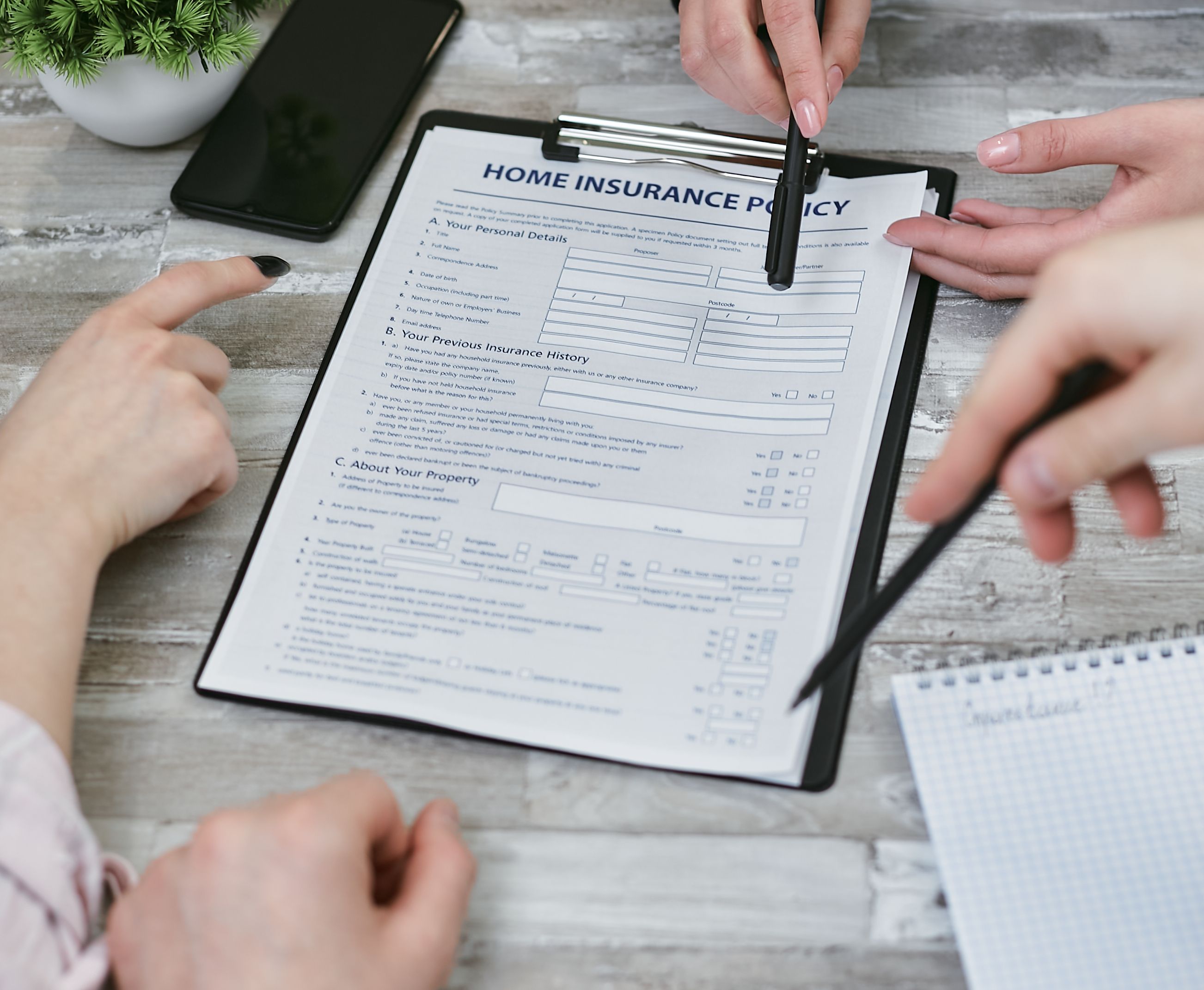 People reviewing insurance paperwork together at a desk