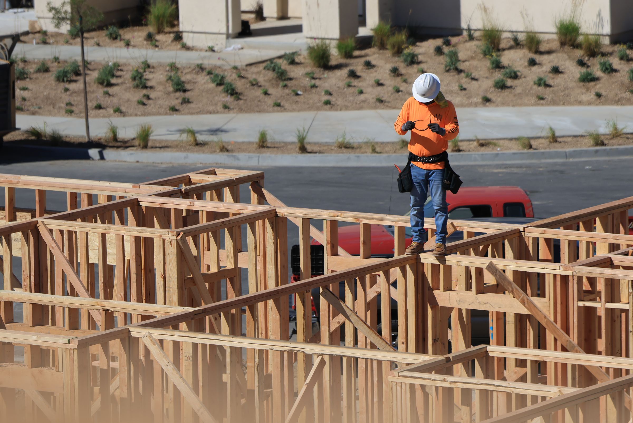Contractor in safety gear at a timber-framed residential construction site